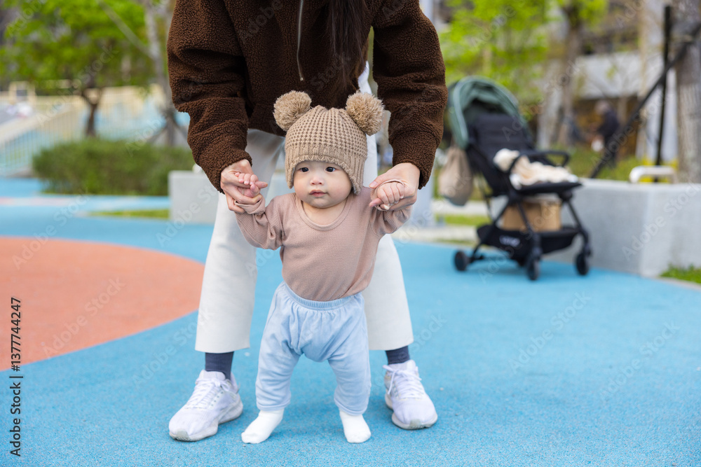 Happy baby learning to walk with mother