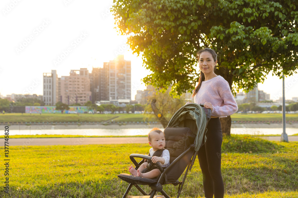 Mum Taking Baby on Stroller to River Park at Sunset