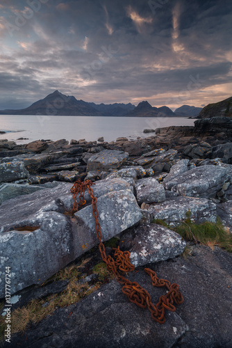 Obraz na płótnie Dramatic waves crash against Elgol’s rugged coast, with the Cuillin Mountains rising in the misty distance. Autumn’s golden light enhances this wild, untamed beauty. w salonie
