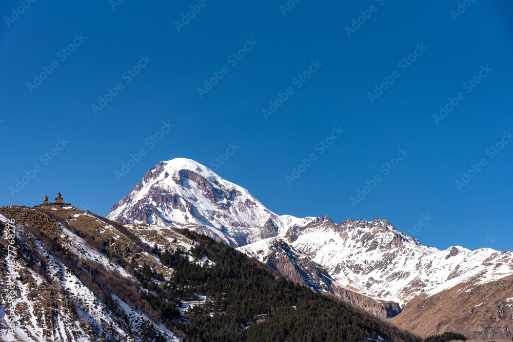 Picturesque winter view of Gergeti Trinity Church and Mount Kazbek in the snow, Georgia. Picturesque winter view of Gergeti Trinity Church and Mount Kazbek in the snow, Georgia.