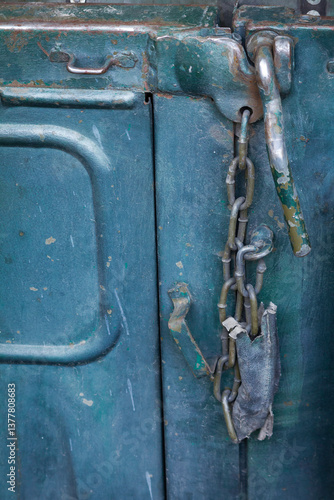 A chain is hanging from a lock on a blue object