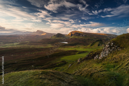 Obraz na płótnie Autumn light bathes the Quiraing on Skye, casting long shadows over its dramatic cliffs and rolling hills. The landscape glows with golden hues, a breathtaking Highland scene. w salonie