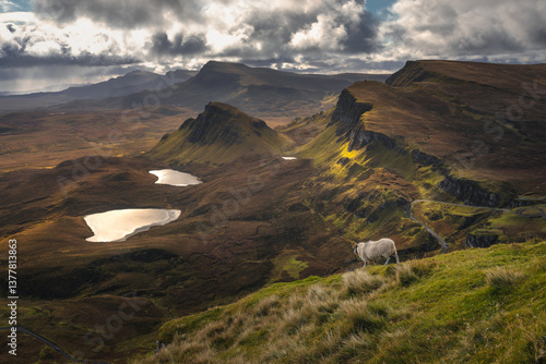 Obraz na płótnie Autumn light bathes the Quiraing on Skye, casting long shadows over its dramatic cliffs and rolling hills. The landscape glows with golden hues, a breathtaking Highland scene. w salonie