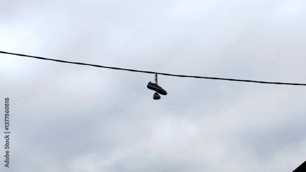 Sneakers hang from wires and sway in the wind Sneakers hang from wires and sway in the wind