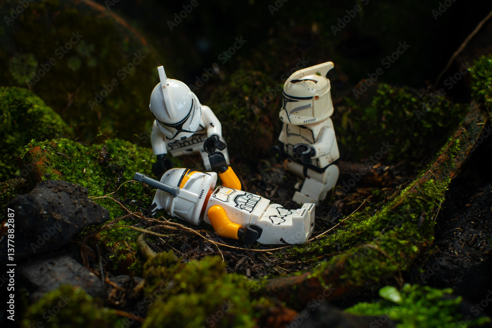 Obraz premium Depok, Indonesia - April 1, 2025: Lego toys photography, clone trooper commander dying in dark forest covered with moss, with bokeh background