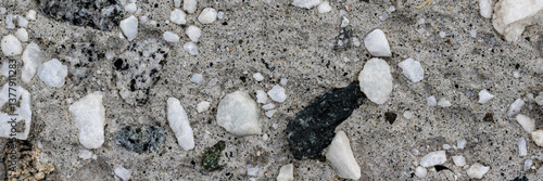 Obraz na płótnie Concrete wall texture with pebbles. Decorative rough concrete surface with white, black and gray stones. Wide panoramic texture for background and design. w salonie
