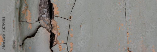 Obraz na płótnie Peeling paint on the wall. Panorama of a concrete wall with old cracked flaking paint. Weathered rough painted surface with patterns of cracks and peeling. Panoramic texture for background and design. w salonie