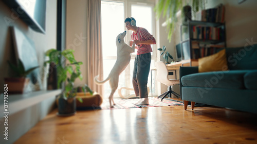 Wallpaper Mural Side view of Caucasian woman wearing headphones. Pretty female holding paws of her dog while standing before large panoramic window. Happy owner dancing with her lovely pet in cosy home. Torontodigital.ca