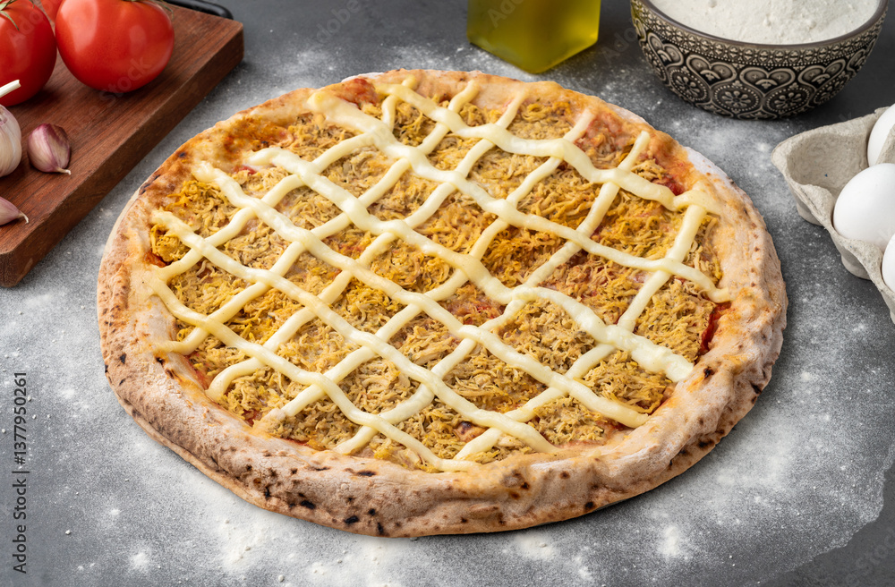 Chicken and Catupiry cream cheese pizza over stone background with flour, tomatoes and eggs Chicken and Catupiry cream cheese pizza over stone background with flour, tomatoes and eggs