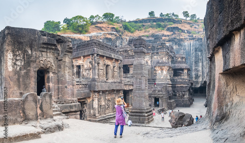 Tourist exploring amazing Ellora Caves, extraordinary rock cut temples famous unesco travel destination, India
