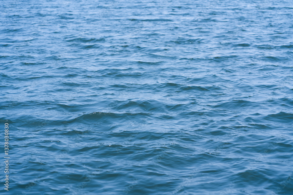 Close-up of calm blue water with gentle waves. A natural and soothing background ideal for themes of tranquility, nature, travel, ocean, and serenity. Close-up of calm blue water with gentle waves. A natural and soothing background ideal for themes of tranquility, nature, travel, ocean, and serenity.
