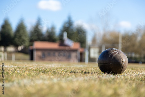 american football ball, worn american football ball and football field, grass and white lines, leather ball