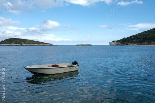 Small boat floating on calm blue sea