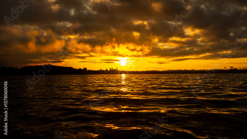 Landscape photo of surface water of lake at sunrise time with golden light tone.