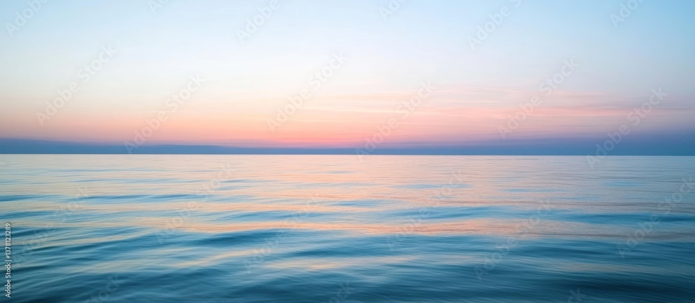 Fototapeta premium Peaceful oceanic waters reflecting colors from the pastel sunset above