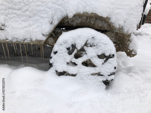 Obraz na płótnie Rear wheel of a snow covered off-road vehicle SUV car parked outdoor on a winter ski slope w salonie