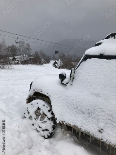 Snow covered off-road vehicle SUV car parked outdoor on a winter ski slope