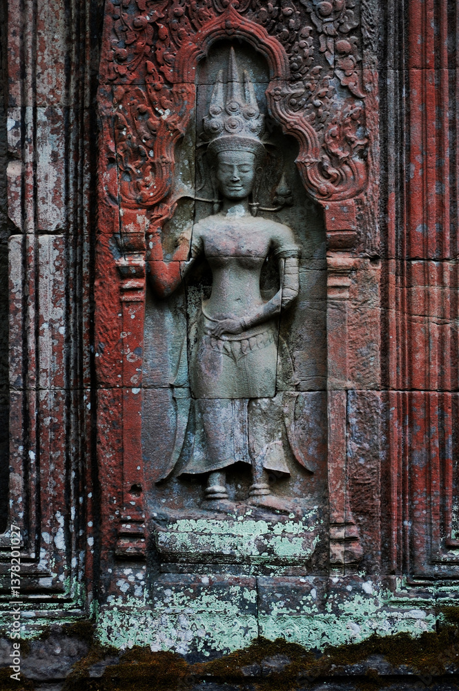 Naklejka premium Sculpture carving figure apsaras or apsara angel deity female spirit of clouds waters and superb art of dancing in Prasat Ta Prohm or Ancestor Brahma temple of Angkor Thom Wat in Siem Reap, Cambodia