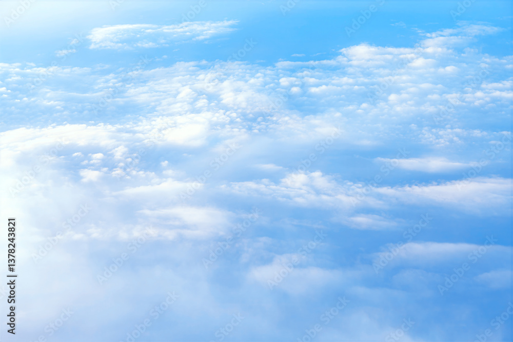 Panoramic view of the atmosphere, with fluffy clouds scattered across the sky. Vast expanse of soft, white clouds, gently drifting across a pale blue sky