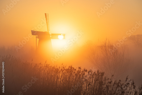 Obraz na płótnie Sunrise at a Dutch, traditional windmill and a canal in the spring fog. w salonie