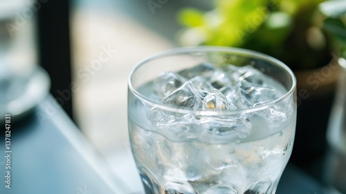 A transparent glass filled with glistening ice cubes and pure water, captures the essence of refreshment, hydration, and clarity, inviting viewers to quench their thirst.