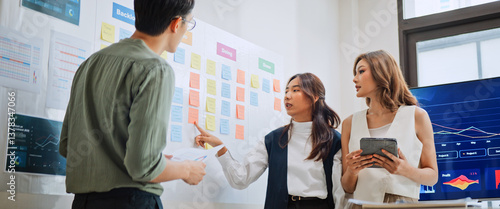 Group of Asian generation z business people work together in home office. Financial team businesspeople brainstorm meeting, use digital tablet and white board presentation. Corporate teamwork concept