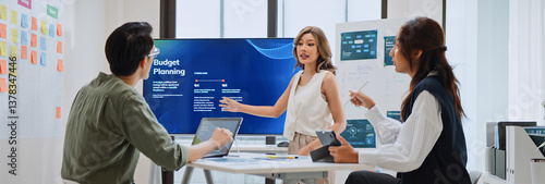 Group of Asian generation z business people work together in home office. Financial team businesspeople brainstorm meeting, use laptop computer and presentation screen. Corporate teamwork concept