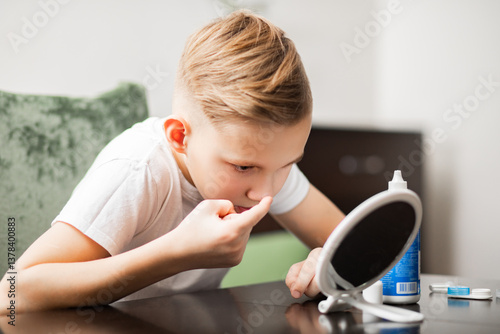Foto Kid teenager boy inserting contact lenses into her eye