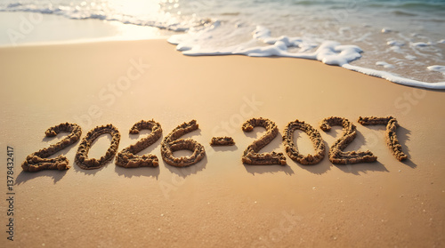 The years 2026-2027 are written in the sand on the ocean shore. The waves wash away the years 2026-2027.