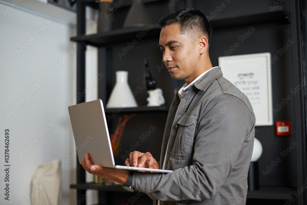 Professional Individual Using a Laptop in a Modern Office Environment with Contemporary Decor Professional Individual Using a Laptop in a Modern Office Environment with Contemporary Decor