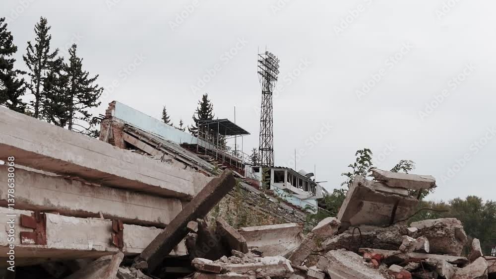 Old broken abandoned sports football stadium with stands and seats. War in Europe between Russia and Ukraine. Military conflict. Destroyed building after missile attack and air strike. Old broken abandoned sports football stadium with stands and seats. War in Europe between Russia and Ukraine. Military conflict. Destroyed building after missile attack and air strike.