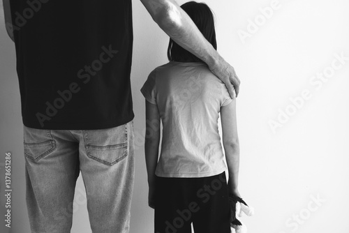 Foto Black and white image of man standing beside a child with his hand gently restin