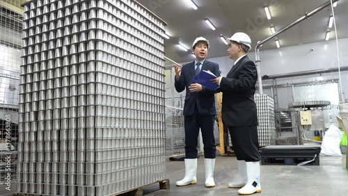 Wallpaper Mural Businessman owner and partner discuss aluminum inspect cans for process canned fish in manufacturing food facility. Torontodigital.ca