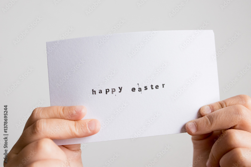 Hands holding happy Easter card with handwritten message on white background Hands holding happy Easter card with handwritten message on white background