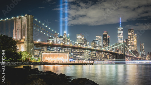 Night view during 9 11 of lower Manhattan and the Brooklyn Bridge with the Tribute in Light in the background