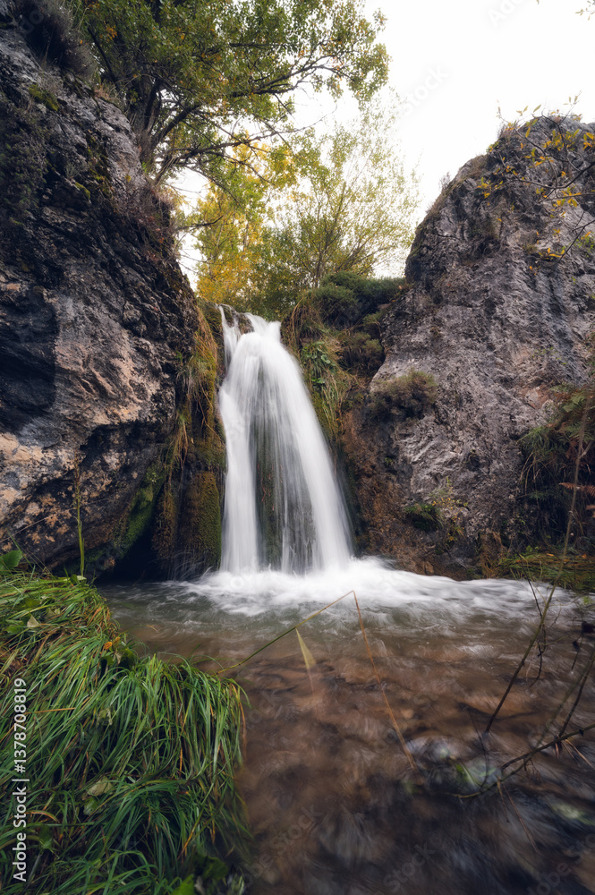 Obraz premium watewaterfall in autumn with green leaves