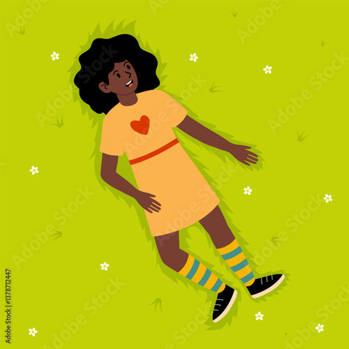 Girl with curly hair relaxing on grass while wearing colorful striped socks