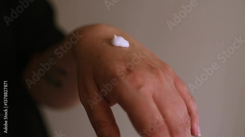 Woman applying moisturizing cream product on hands close up. Selective focus.