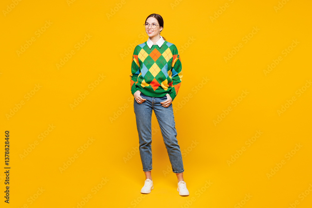 Fototapeta premium Full body young smiling happy smart woman she wear glasses green sweater casual clothes stand look aside on area mock up isolated on plain orange yellow background studio portrait. Lifestyle concept.
