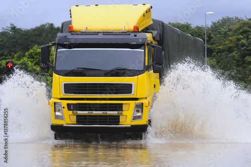 Heavy vehicles wade through the floodwaters