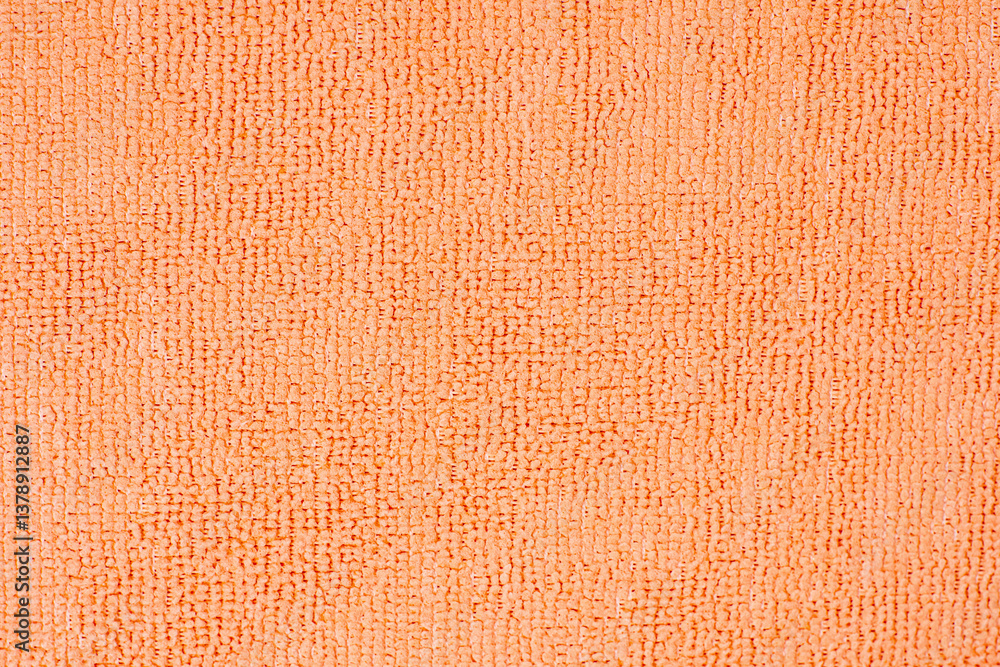 Fototapeta premium Microfiber cleaning cloth surface texture close up showing the looped pile of the fabric in vivid orange color, ideal for backgrounds and textures