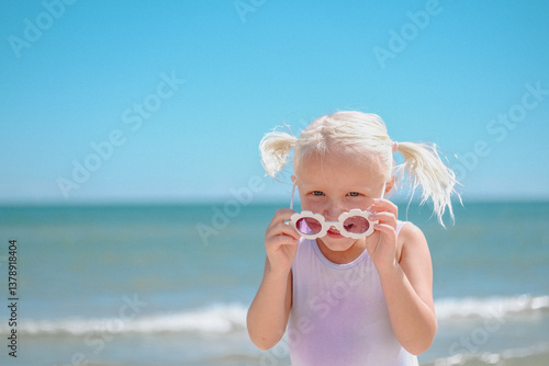 little girl with sun glasses on the beach
