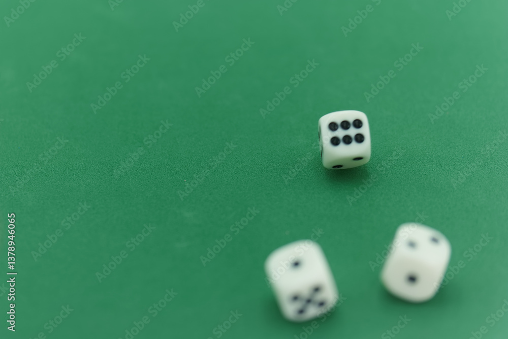 Three white dice resting on a green felt gaming table after bein