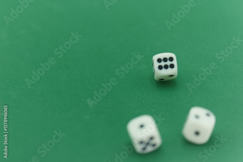 Three white dice resting on a green felt gaming table after bein