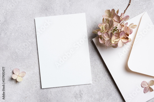 Wedding invitation card mockup with white envelope and dried flowers decor, blank paper card mock up with copy space on grey background