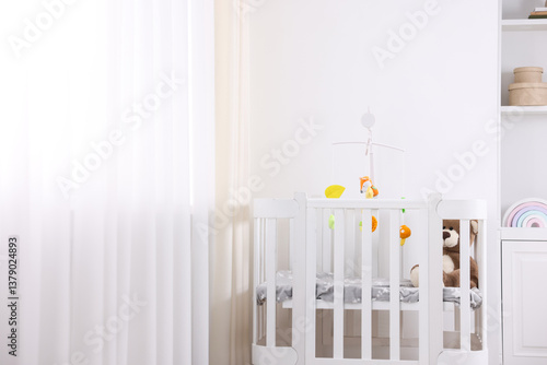 Cute baby mobile with crib in room