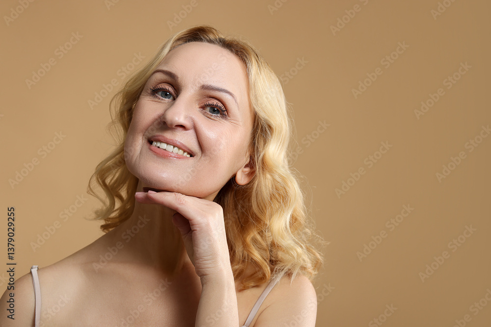 Portrait of smiling middle aged woman on beige background. Space for text Portrait of smiling middle aged woman on beige background. Space for text