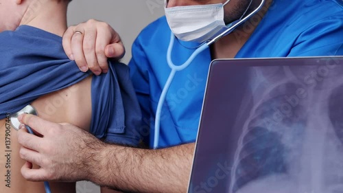 x ray radiography of kid lungs affected by pneumonia bacteria. image on tablet in front of boy chest.doctor listening with stethoscope little child.Pediatrician checking health condition of preschoole