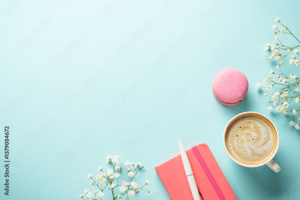 Cup of coffee, macaroon and flower on blue background.