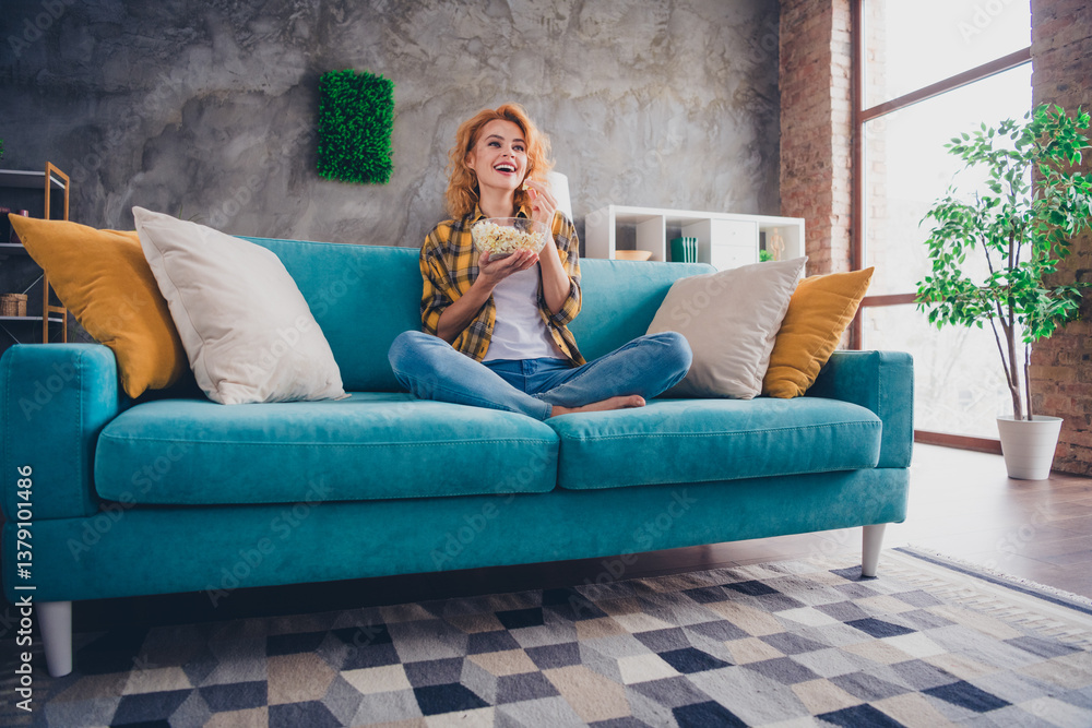 Obraz premium Full size photo of young blonde woman excited watch tv eat popcorn dressed yellow plaid outfit cozy day light home interior living room